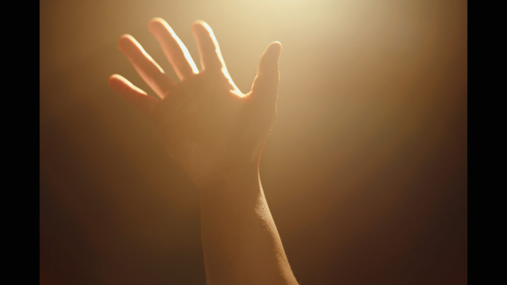 Misha's hand reaches towards the ceiling.