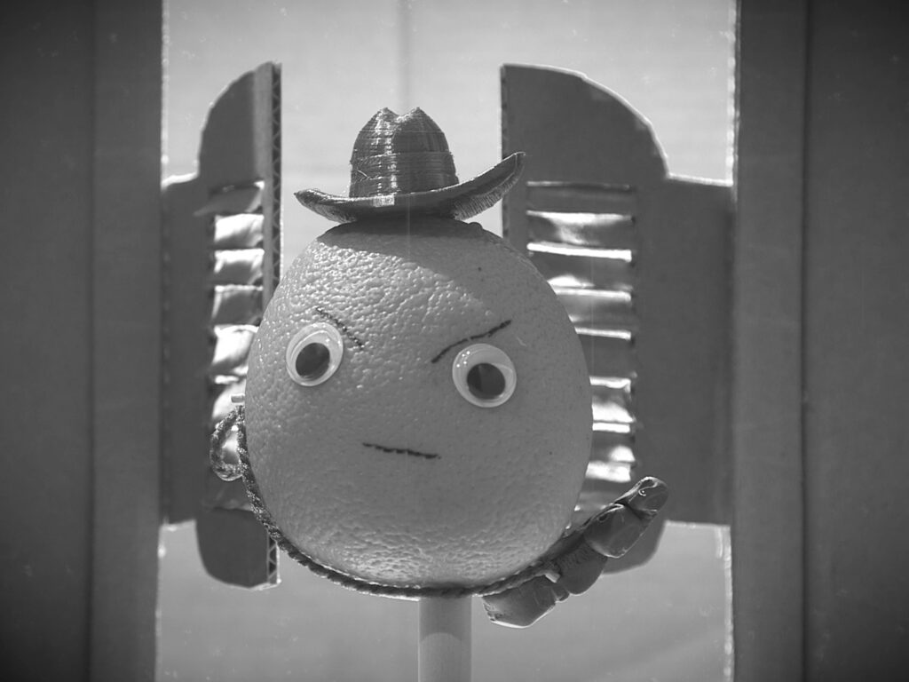 The Sunkist Kid enters through the saloon doors.