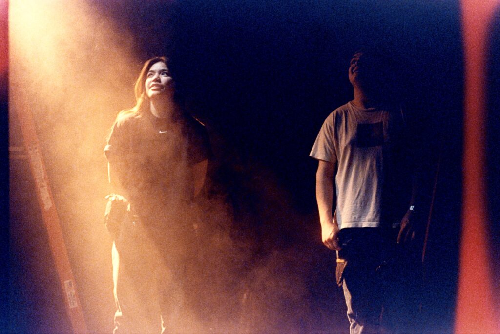 Mary (key grip) spots a ladder while Nic (rigging grip) looks on.