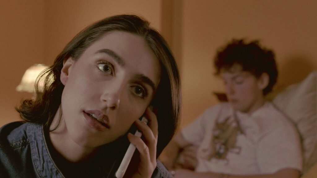 Graham talks on the phone while Holden (played by Parker Mason) sits in the background.